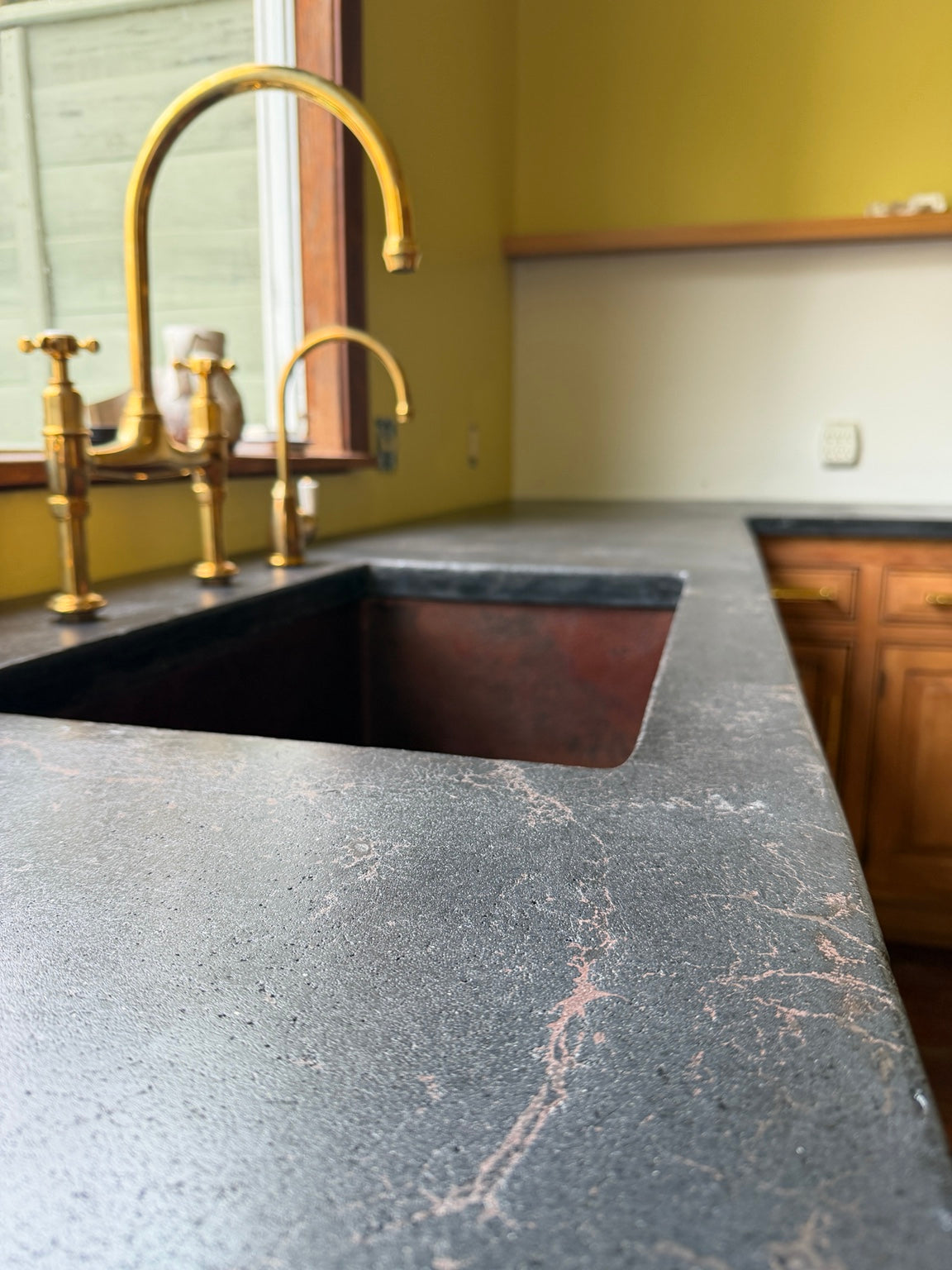 Custom architectural concrete countertop in a warm contemporary kitchen